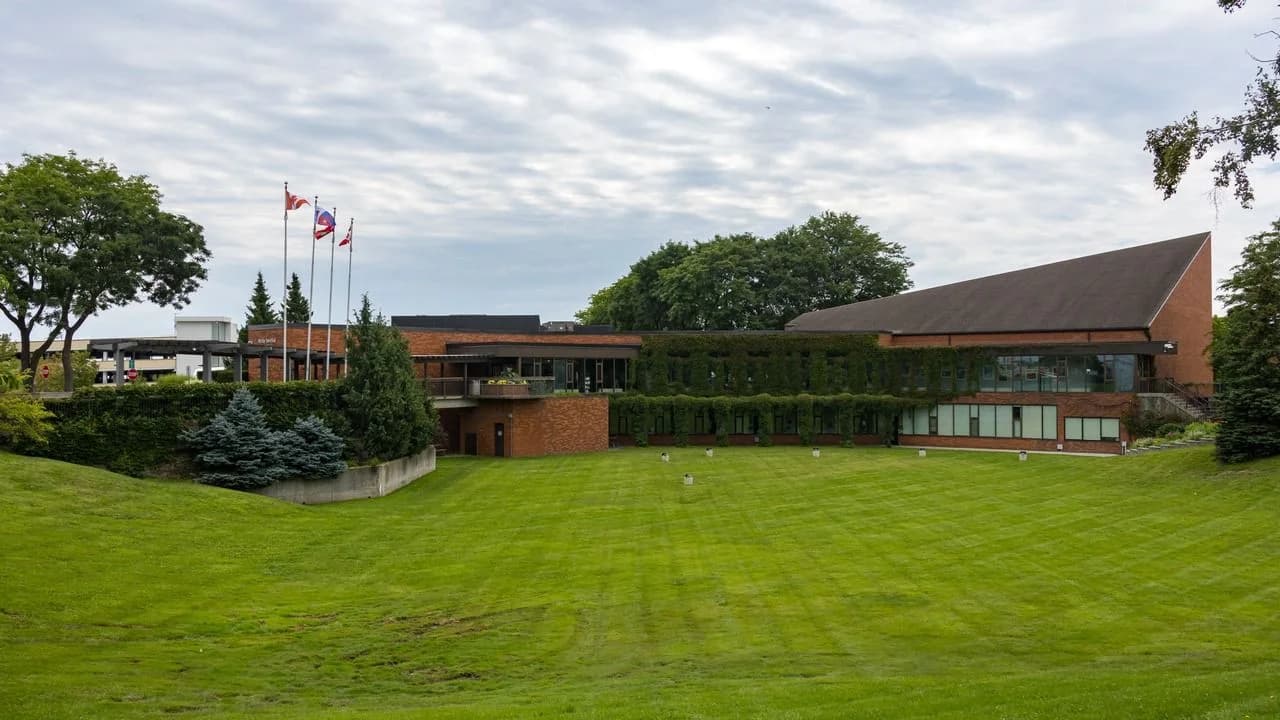Whitby Town Hall on Rossland Road with flags flying and a lawn in front; no people visible.